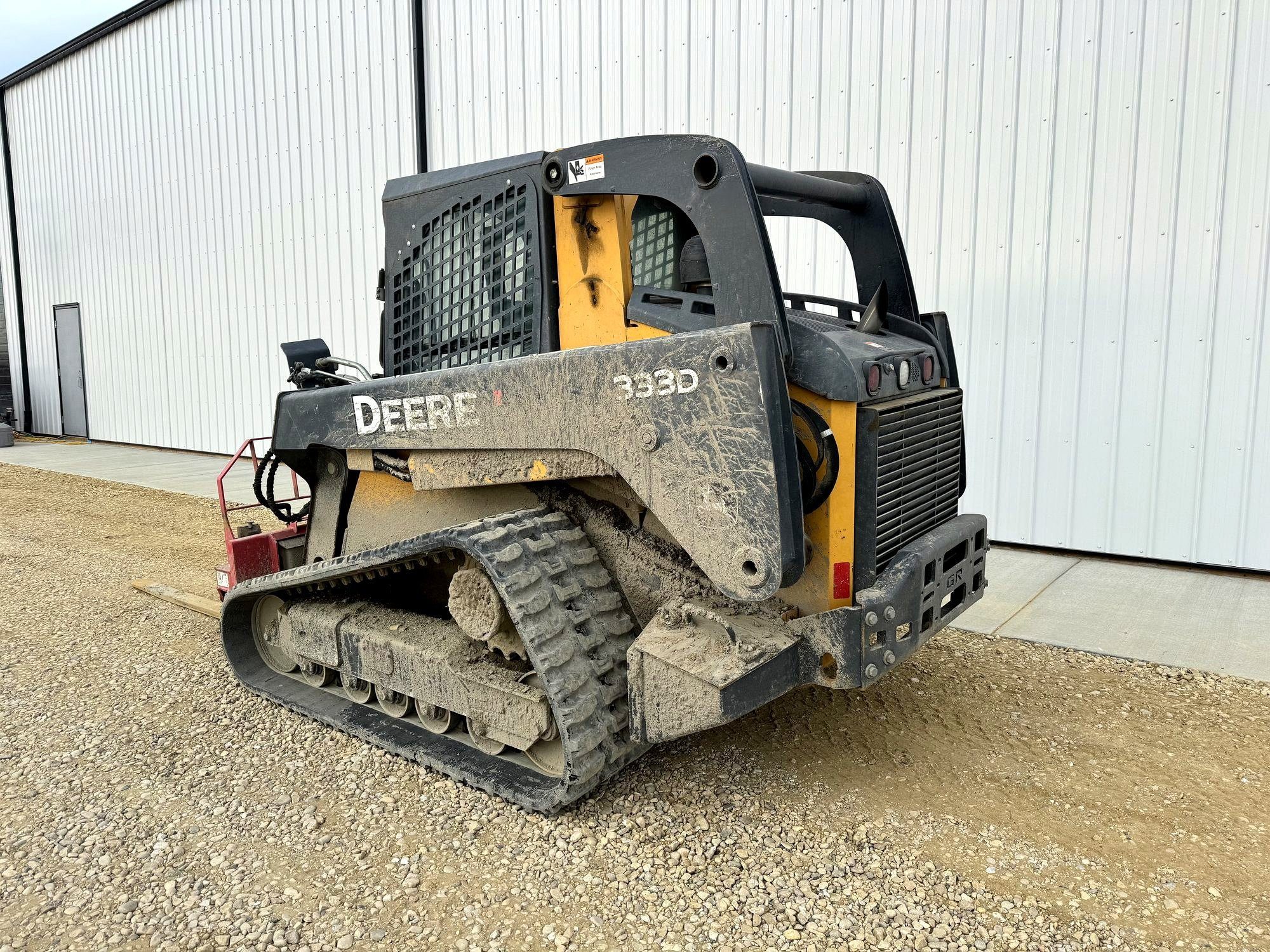 A compact track loader standing in the yard