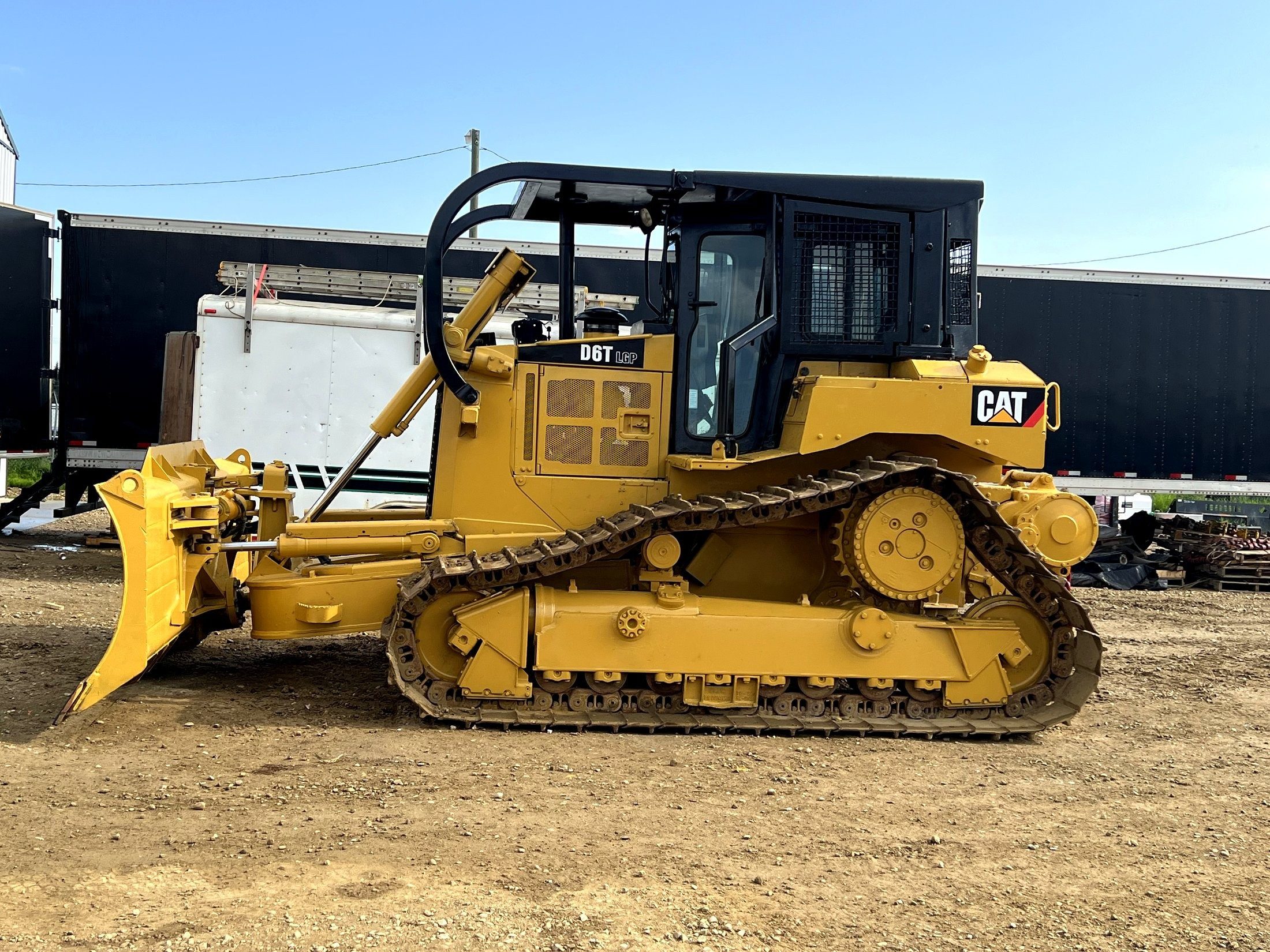 A low-ground-pressure dozer in the yard, blade down, side on