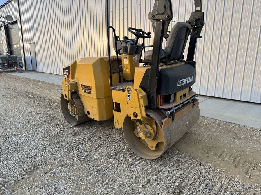 A packer compactor standing beside the shop