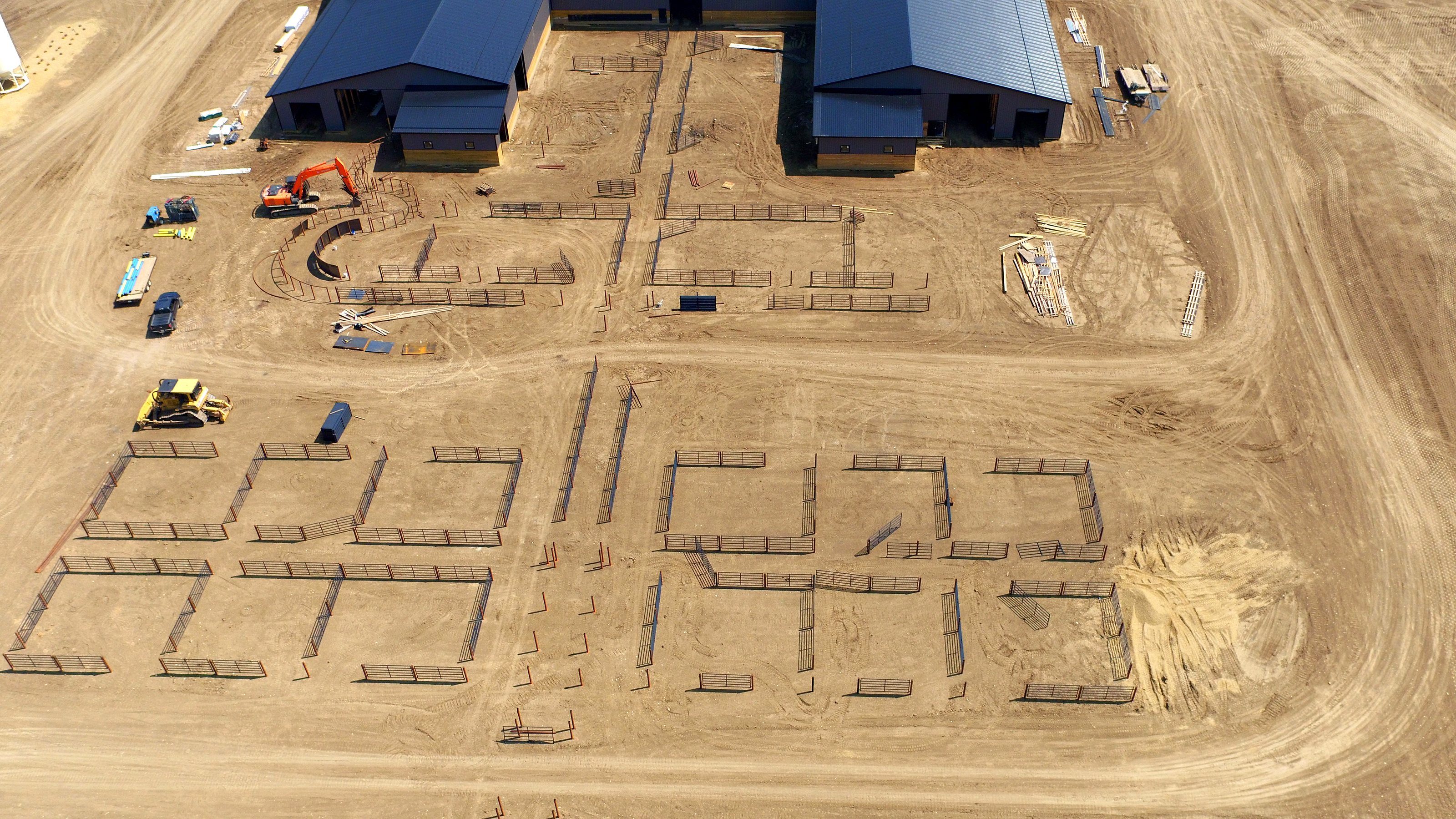 The pens under construction from the air, the layout cut into the ground, machines at work