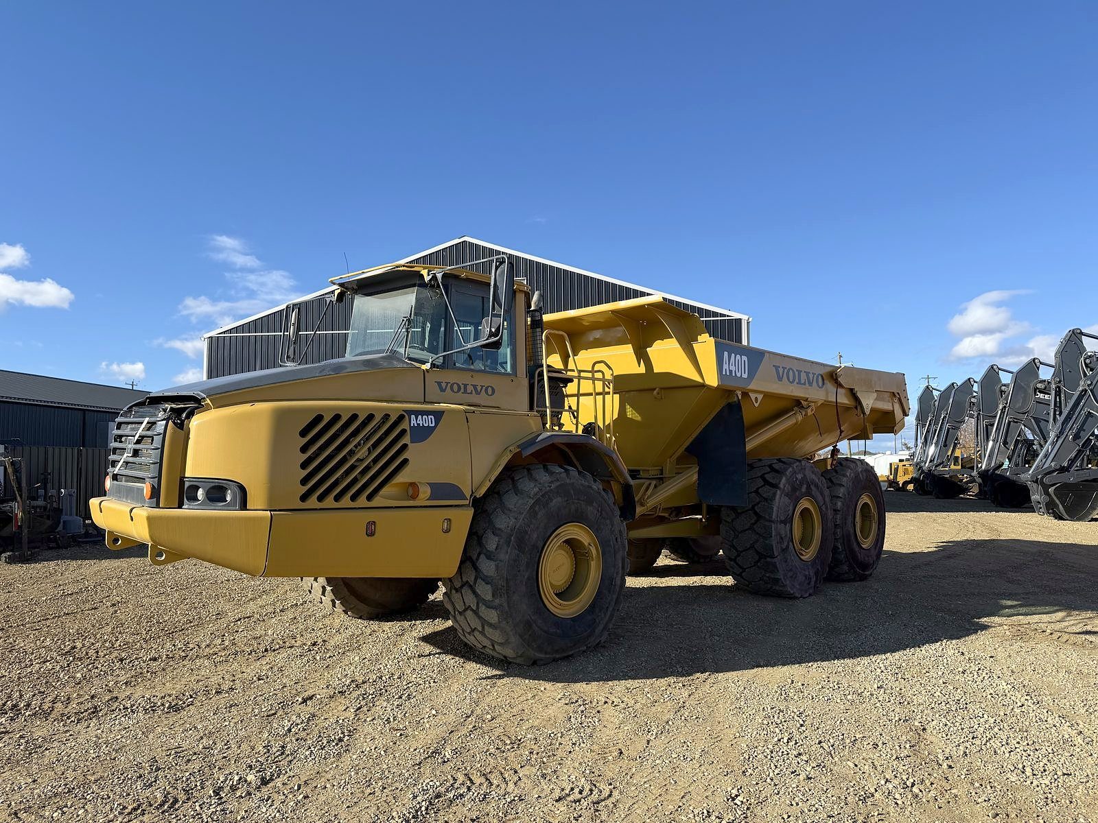 An articulated rock truck in the yard, front three-quarter