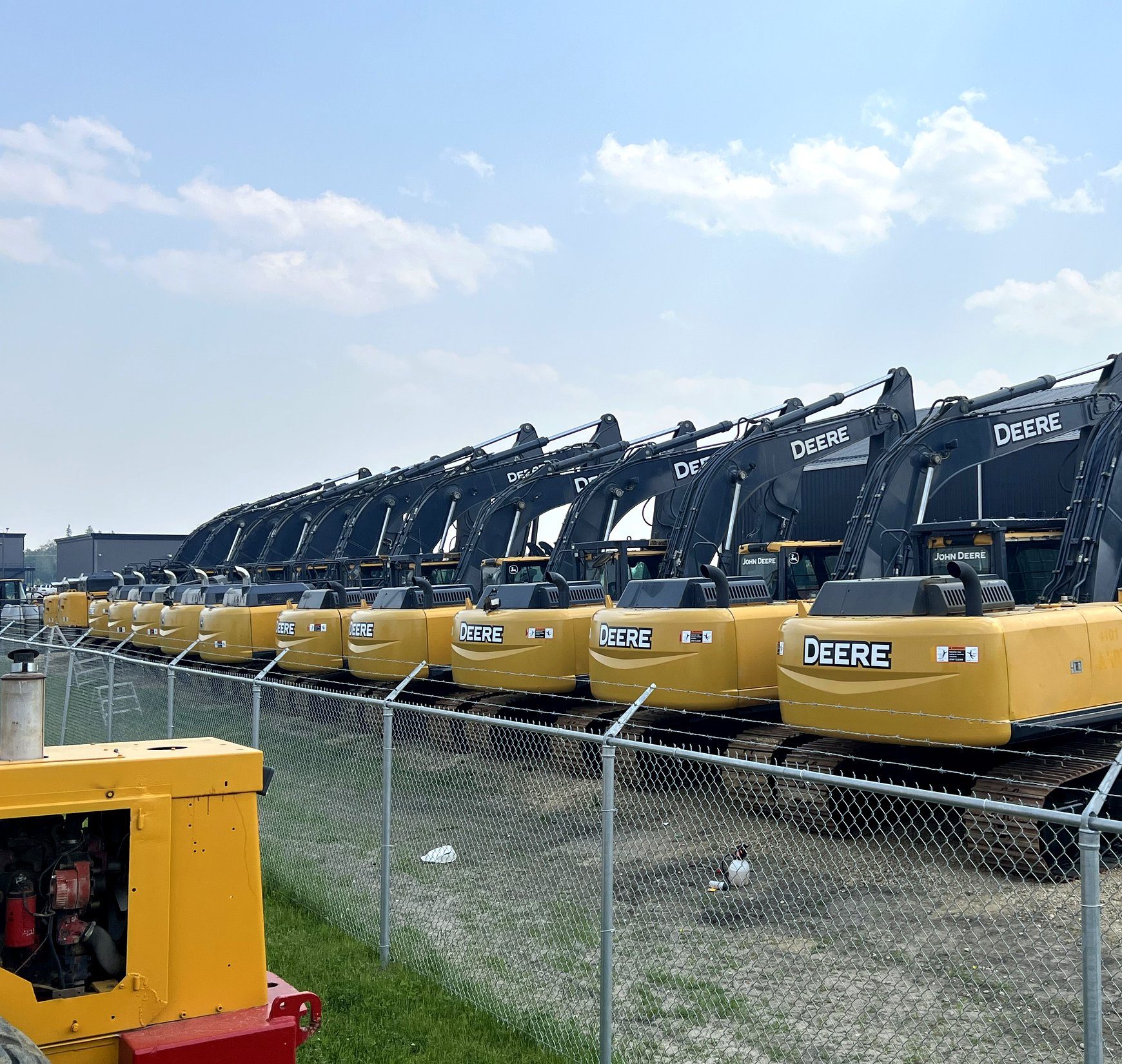 A row of machines standing behind a fence in the yard