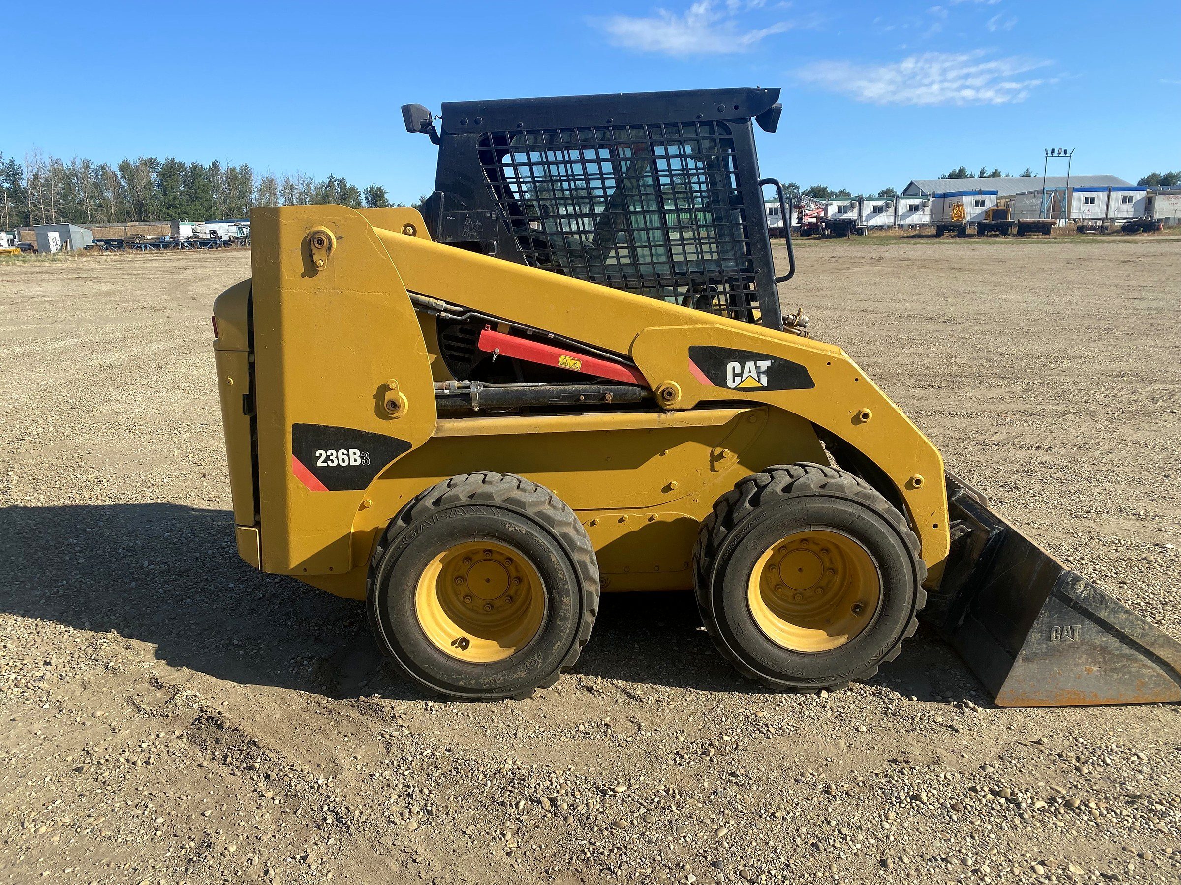 A skid steer in the yard, seen from the side