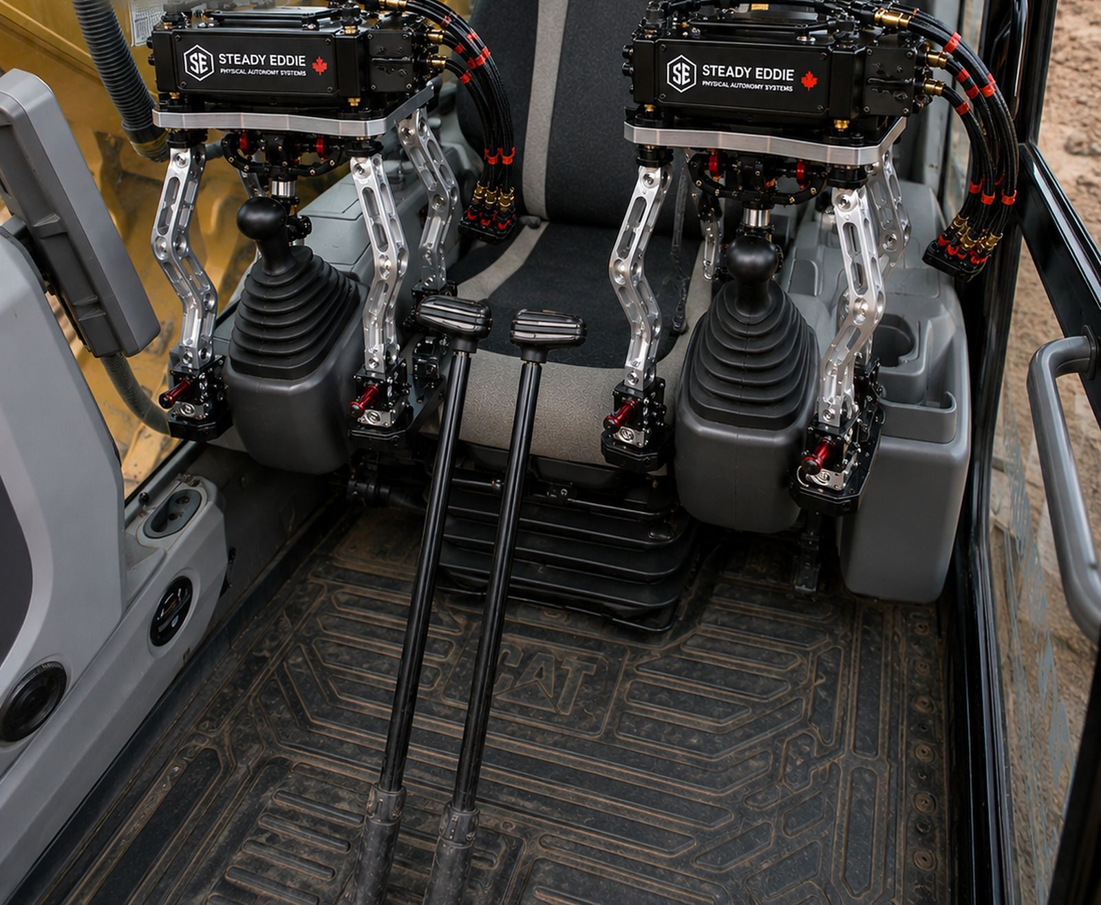 An excavator cab with kit fitted on both joysticks and the display between them
