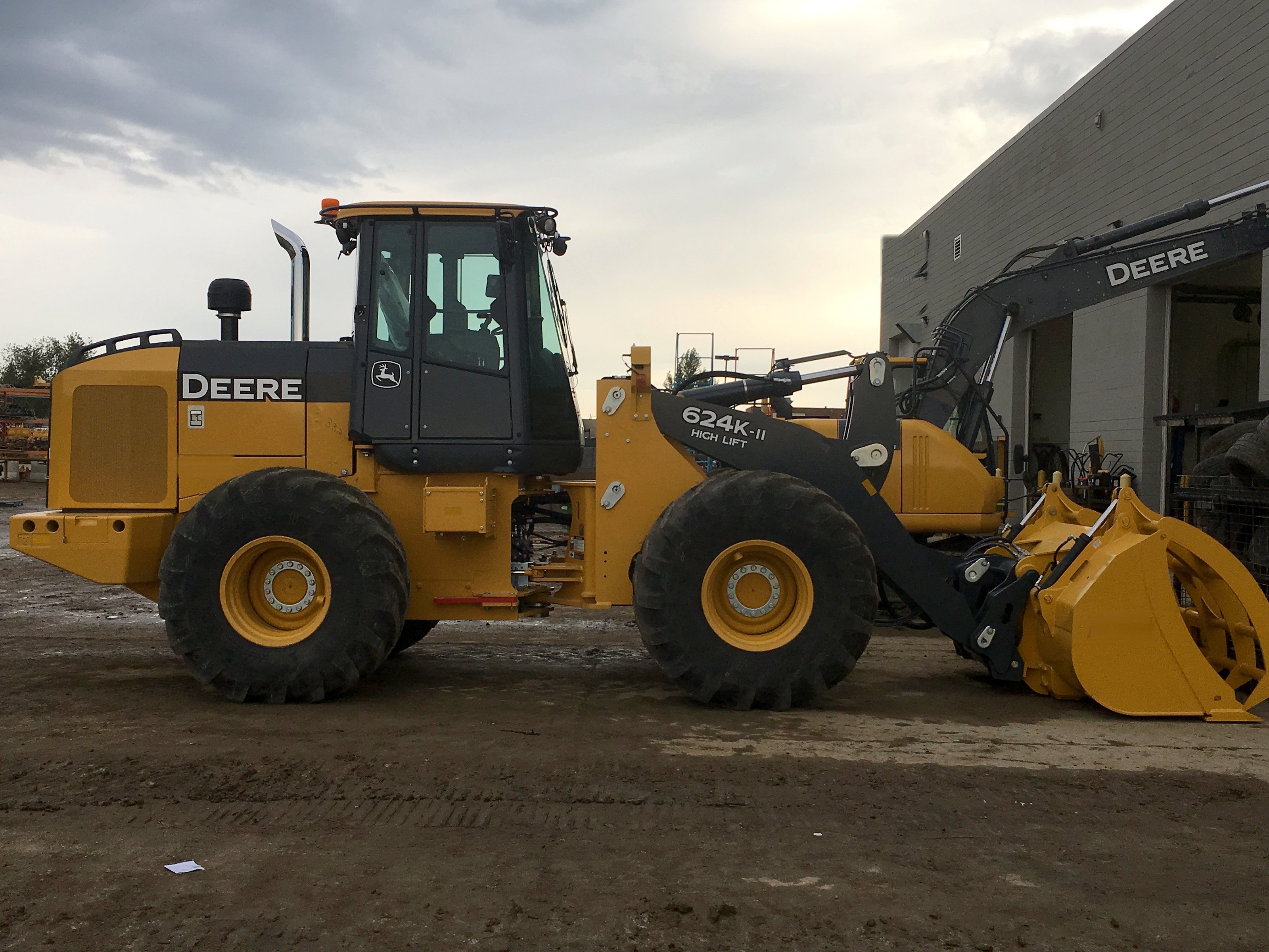 A wheel loader beside the shop with its bucket up